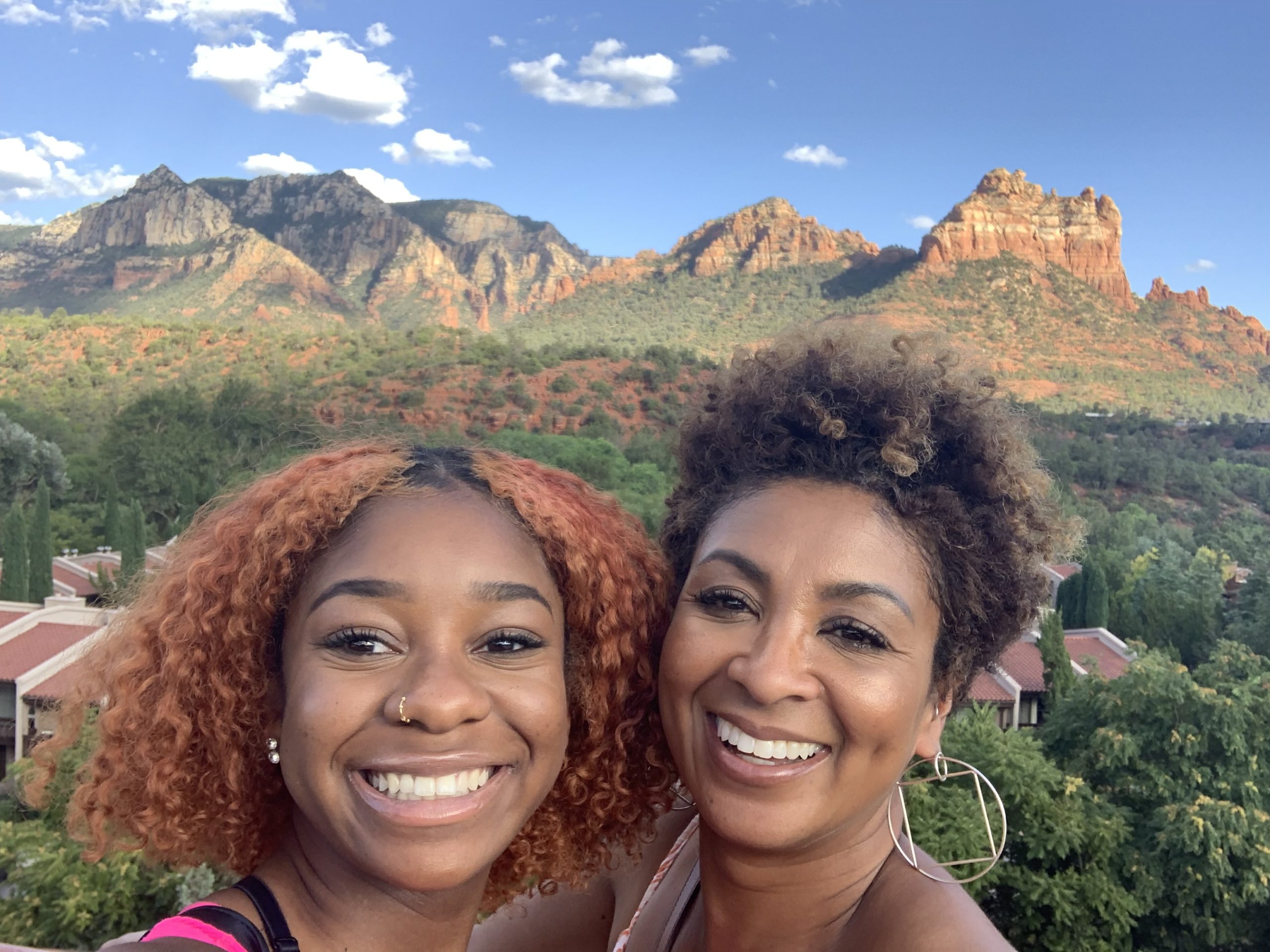 Mother and daughter smiling together with Sedona red rock formations in the background